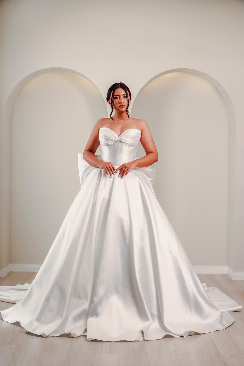 Noiva usando vestido em cetim com busto torcido e volume elegante