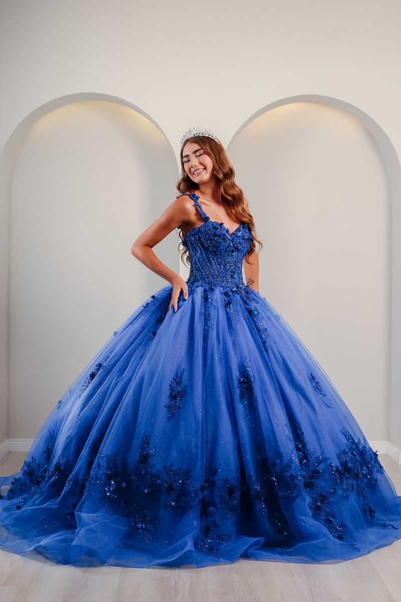 Vestido de debutante azul royal com saia ampla, bordados escuros e brilho delicado